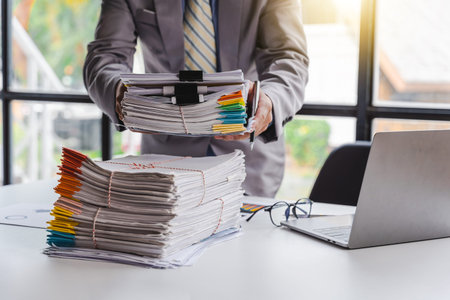 Stack of documents, pile of papers on office desk employee's table, closeup, Asian people.