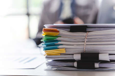 Stack of documents, pile of papers on office desk employee's table, closeup, Asian people.の写真素材