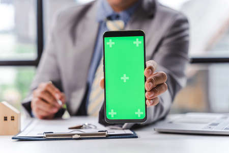 Blank screen mobile, Business man with house model for tax loan or buy new.の写真素材
