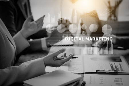 Business environment with professionals and graphics overlay with the text "DIGITAL MARKETING" during a meeting.の写真素材