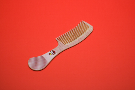 Large comb shot on a plain red isolated background.の写真素材