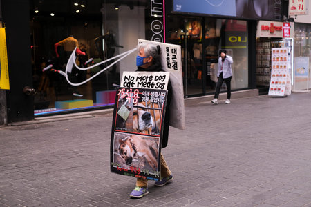 MYEONGDONG, SEOUL - An Elderly holding poster to stop Animal Abuse and eating Dog spotted in the street.のeditorial素材