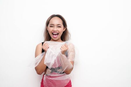Girl holding in  her and plastic wrap on an isolated background.の写真素材