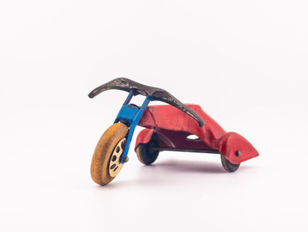 A vintage metal tricycle toy in the color red. It's taken on a white backgroundの写真素材