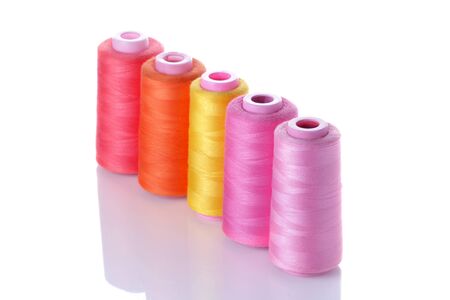 Multicolored spools with threads on white isolated background. accessories for sewingの写真素材