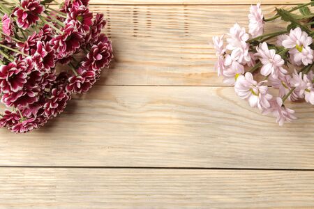 Frame of autumn flowers of chrysanthemums on a natural wooden background. top viewの写真素材