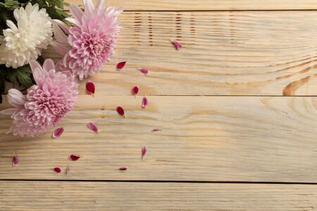 Frame of autumn flowers of chrysanthemums on a natural wooden background. top viewの写真素材