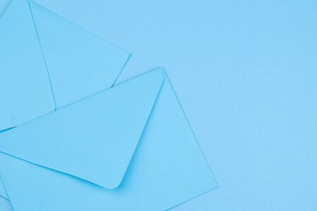 Blue postal envelopes on a bright trendy blue background. Concept for mail or delivery.の写真素材