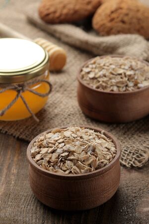 Dry oatmeal, honey and oatmeal cookies. food. healthy food. on a brown wooden table.の写真素材