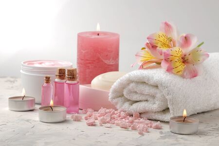Spa composition with sea salt, aroma oils, towels and soaps and body scrubs. spa concept. on a light background.の写真素材