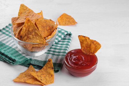 Chips. Nachos in a bowl with red sauce on a white wooden table. Snacks.の写真素材