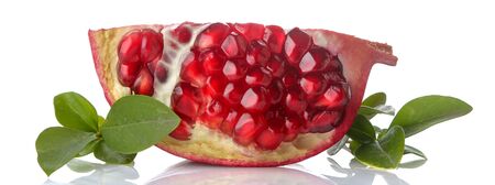 Red half of pomegranate fruit with grains and green leaves close up on an isolated white backgroundの写真素材