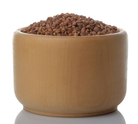 Buckwheat groats in a wooden bowl on a white isolated background. porridge. healthy food. cerealsの写真素材