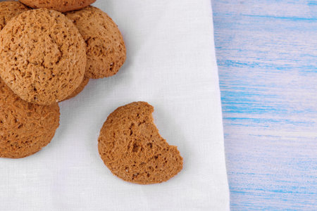 oatmeal cookies piled on a white napkin on a blue wooden table. bake. yummy.