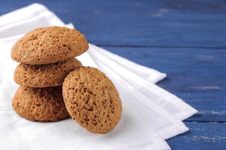 oatmeal cookies piled on a white napkin on a blue wooden table. bake. yummy.の写真素材