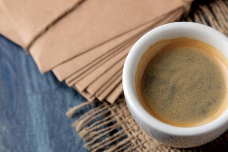 Natural espresso coffee in a ceramic coffee cup on a blue wooden table. close-upの写真素材