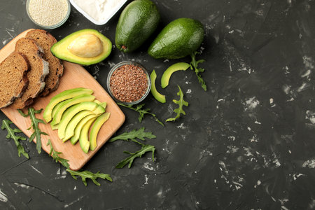 Avocado, butter, bread. ingredients for making avocado sandwiches. On a dark background. view from...