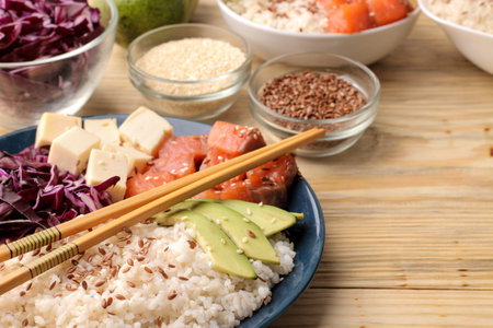 poke bowl Hawaiian food. a plate of rice, salmon, avocado, cabbage and cheese. next to sesame seeds...