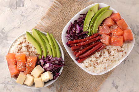 poke bowl Hawaiian food. a plate with rice, salmon, avocado, cabbage and cheese on a light background.の写真素材