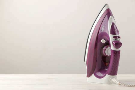 lilac iron on a light background. ironing clothes. household electrical appliances.の写真素材