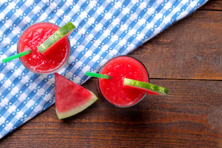Watermelon smoothies with a fresh slice of watermelon on a brown wooden background. Top viewの写真素材