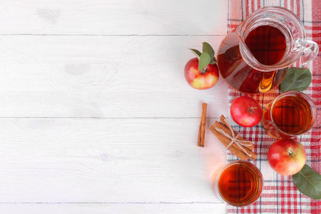 apple juice with fresh apples and cinnamon on a white wooden background top view with place for an...