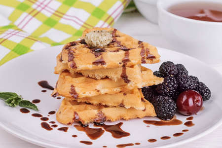 Delicious sweet Belgian waffles in the form of hearts with chocolate and berries close-upの写真素材