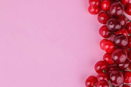Ripe fresh bright cherry lined with a frame on a bright pink background with a place for the inscription. top viewの写真素材