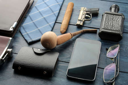 Men's Accessories. men's style. smartphone, business card holder, perfume, smoking pipe, purse on a blue wooden background.の写真素材