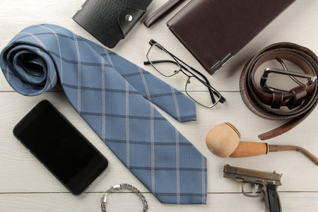 Men's Accessories. men's style. Tie, belt, glasses, smoking pipe, wallet on a white wooden...