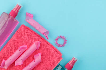 hair cosmetics and hair accessories, hair curlers, combs, barrettes and elastic bands. on a bright blue background. hair care products. top view with space for textの写真素材