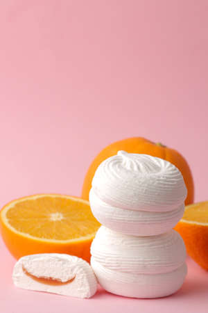 Sweet white round marshmallows with orange filling and oranges on a bright trendy pink background. Sweets. dessert.の写真素材
