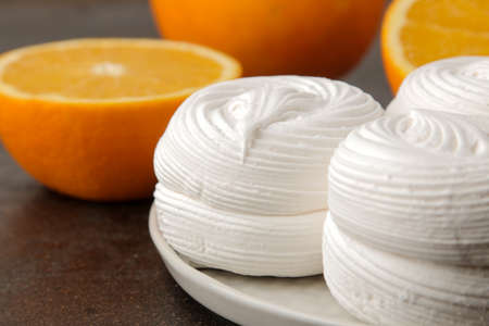 Sweet white round marshmallow with oranges close-up on a brown wooden table. Sweets. dessert.の写真素材