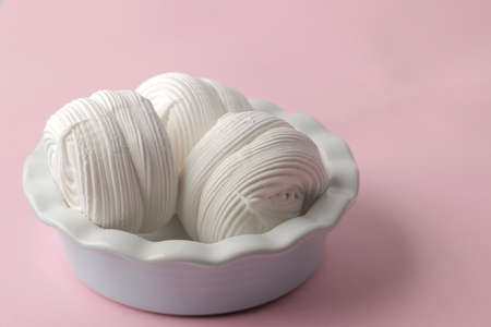 Sweet white marshmallow in a plate on a bright trendy pink background. Sweets. dessert. close-upの写真素材