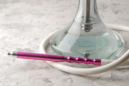 Transparent hookah with a beautiful pink mouthpiece on a light background. hookah accessoriesの写真素材
