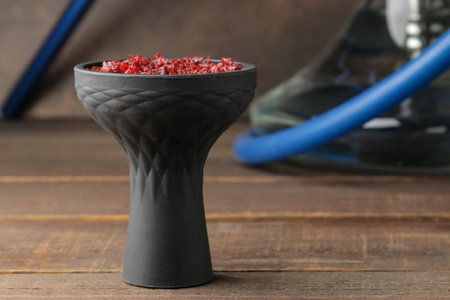 silicone hookah bowl with tobacco on a brown wooden table. close-up. accessories for hookah.