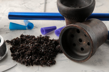 Various accessories for making hookah tobacco, bowl, coal, mouthpiece on a light background....