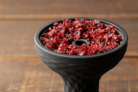 silicone hookah bowl with tobacco on a brown wooden table. close-up. accessories for hookah.