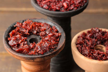 Clay bowls for hookah with tobacco on a brown wooden table. accessories for hookah. close-upの写真素材