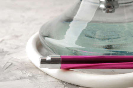 Transparent hookah with a beautiful pink mouthpiece on a light background. hookah accessoriesの写真素材