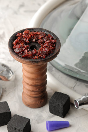 Transparent hookah with a beautiful pink mouthpiece and a clay bowl with tobacco and various accessories for making hookah on a light background. hookah accessoriesの写真素材