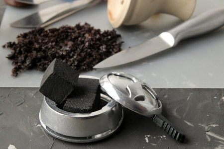 coconut charcoal for calauda hookah close-up on a dark background and various accessories for making...