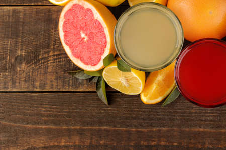 Citrus juices. Lemon and grapefruit juice with fresh fruit on a brown wooden table. with space for text. view from aboveの写真素材