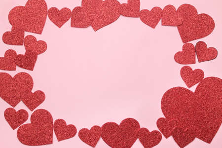 Bright red hearts on a bright pink background. frame of hearts, top view with space for textの写真素材