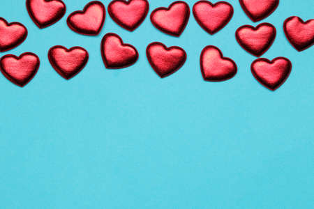 Red hearts on a bright blue background. frame of hearts, top view with space for textの写真素材