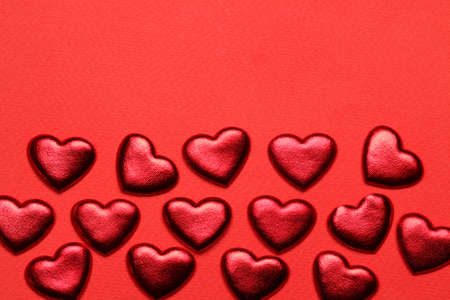 Red hearts on a bright red background. frame of hearts, top view with space for textの写真素材