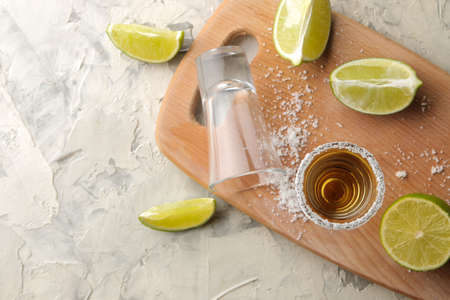 gold tequila in a glass shot glass with salt and lime on a light concrete background. bar. alcoholic beverages. view from aboveの写真素材