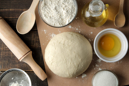 baking ingredients. baking tools. dough and butter, eggs, sugar, milk on a brown wooden background.の写真素材