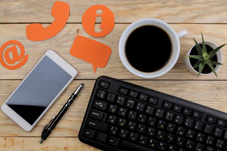 client support service. Contact us for feedback. desktop with a cup of coffee and a smartphone and...