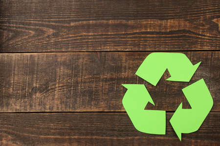 Recycling sign on a brown wooden table. view from above. eco conceptの写真素材
